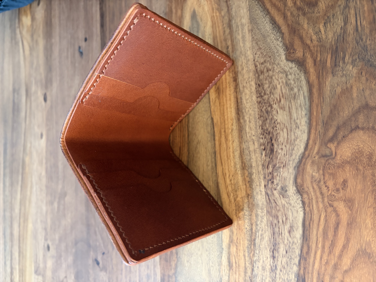 The Heritage bifold wallet laid open, showing six card slots and cash pocket
